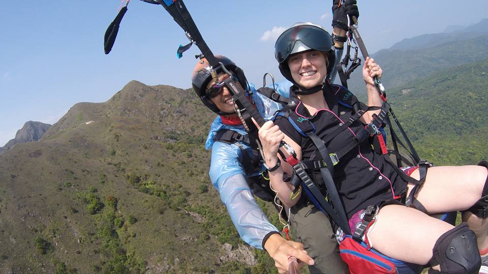 Tandem paragliding above lush hills in Hong Kong